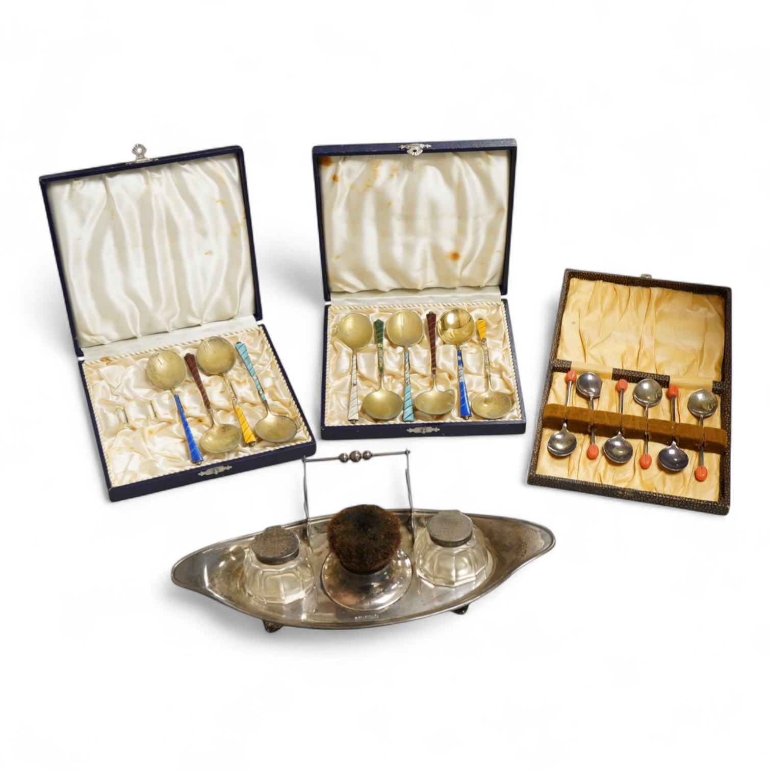 An Edwardian silver elliptical shaped inkstand, with two mounted glass wells and central pen wipe, James Dixon & Sons, Sheffield, 1906, together with ten Danish sterling and polychrome enamel spoons(a.f) and a cased set
